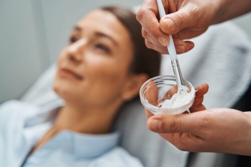 A cosmetician preparing a face mask