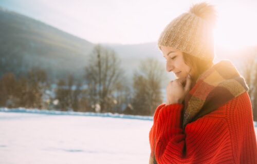 healthy woman walking in the snow dressed in winter clothes