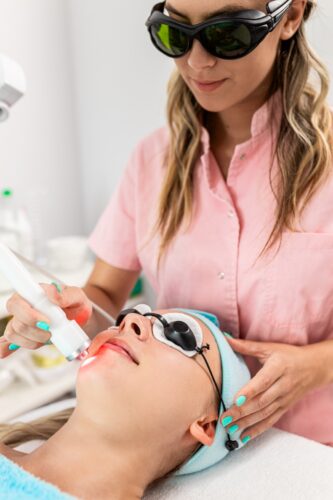 beautician therapist applying moxi laser treatment